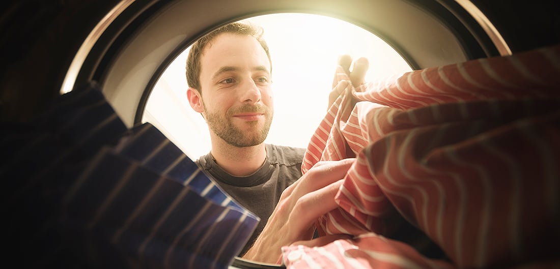 white man looking into dryer